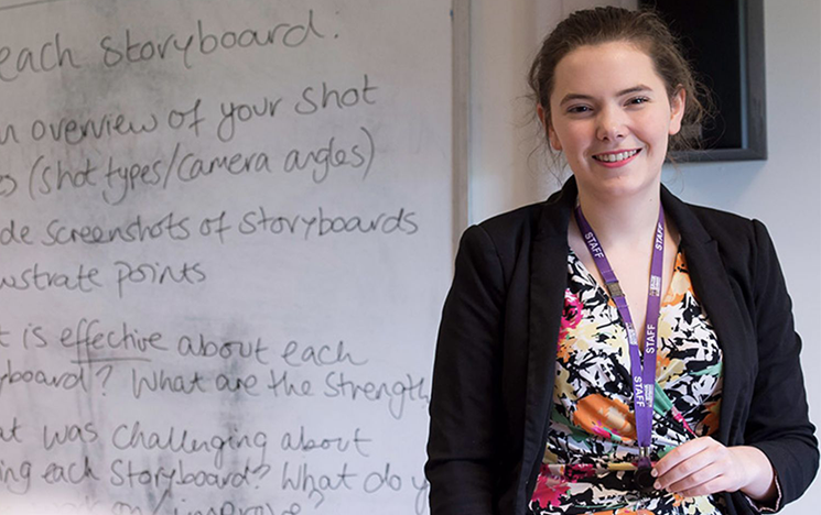 A woman standing in front of a whiteboard.