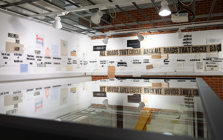 Ane Thon Knutsen's work Mapping Nancy Cunard's Parallax displayed on the exhibition wall, and reflected in the display cabinet in the photo foreground