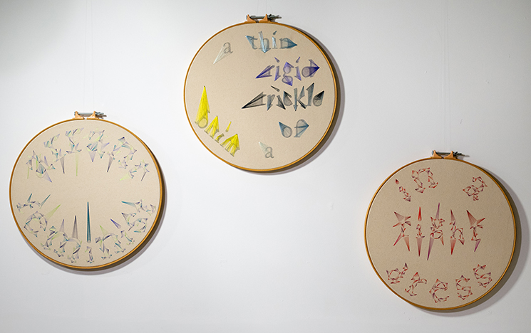 Three of four embroidered wheels by artist Michelle Abbott, illustrating Woolf's insults