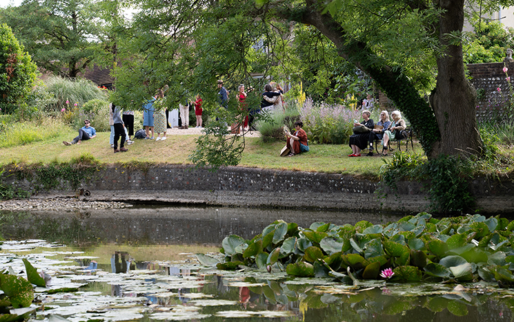 A view of the Charleston pond and tree, with Woolf conference delegates sitting on the grassy bank
