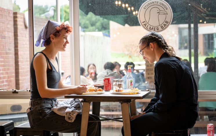  Two students enjoy a meal together at the Sussex Summer School farewell BBQ