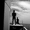 Black and white image of people looking out to sea