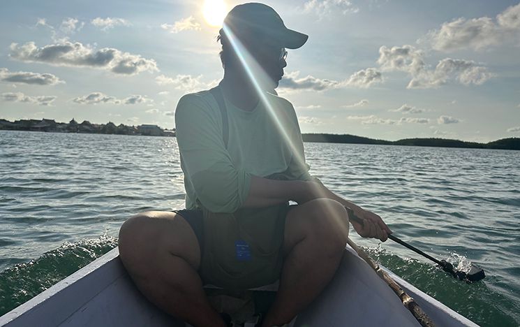 Man on boat with camera in water