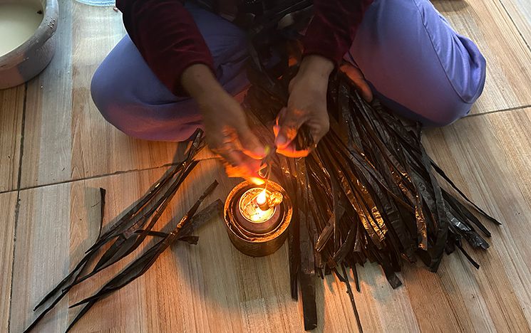 Woman holds plastic tie over flame