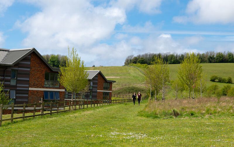Buildings next to grassy hills