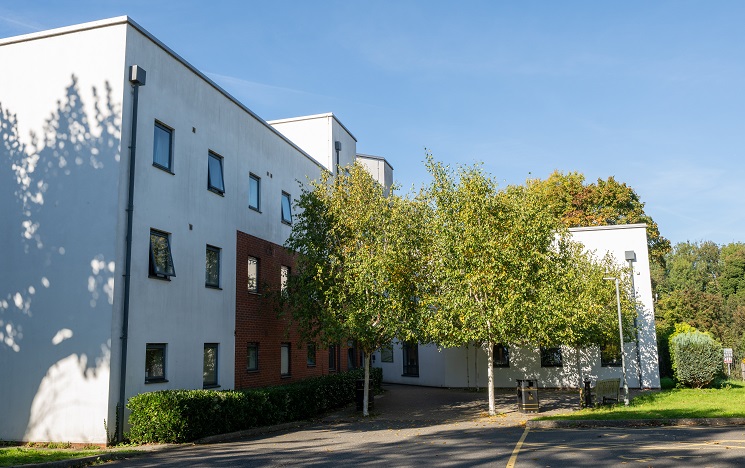 A white-clad block of student accommodation surrounded by trees