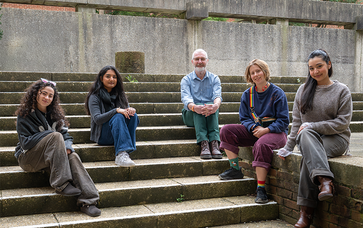 An image of Dr Simon Bowes and four students sitting on some steps