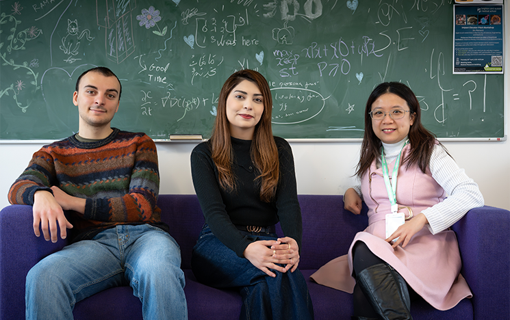 An image of Filippo Giannoni, Eisha Arif and Karrie Liu sitting on a sofa in front of a blackboard