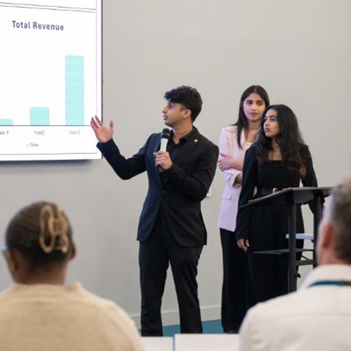 Students presenting a powerpoint in front of an audience.