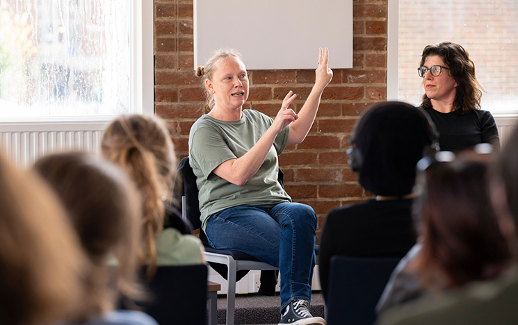 A woman speaks on a panel in front of an audience.