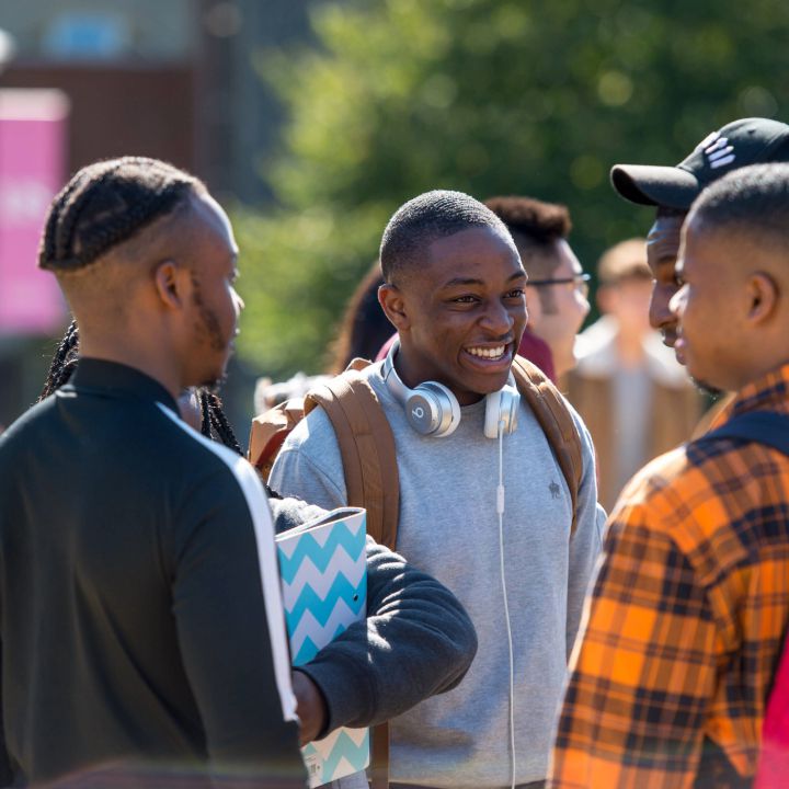 Three students laugh on campus