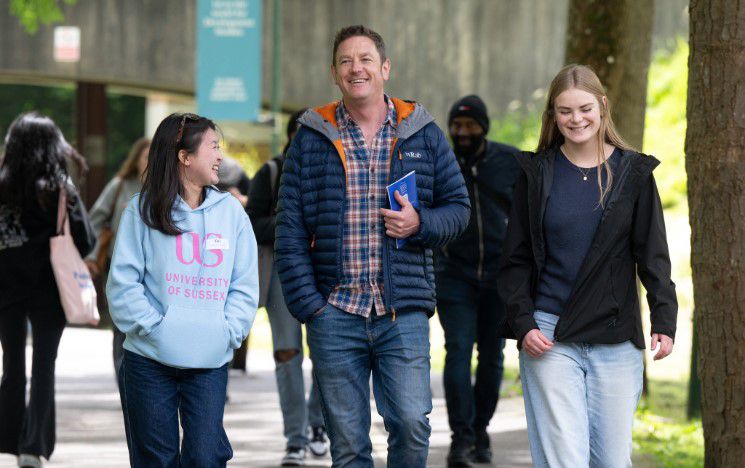 A father and daughter are guided by a volunteer at a campus open day A father and daughter are guided by a volunteer at a campus open day