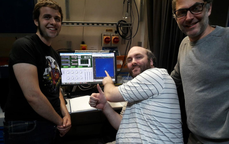 Zak Romaszko wearing a Universal Quantum lanyard holding up a quantum chip.