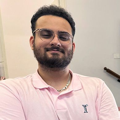 Smiling man wearing a pink top