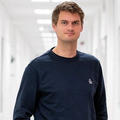 Man standing in bright white corridor