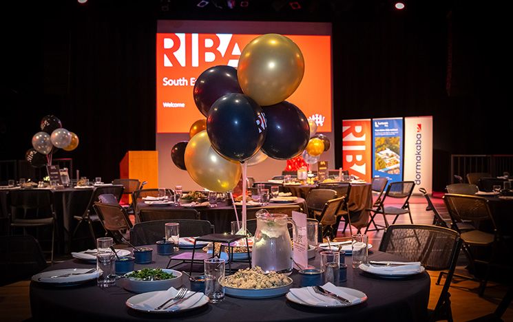 An example of the table set-up for an awards event at the ACCA, including black and gold balloons and a spread of food