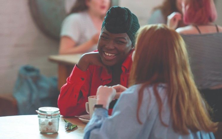 Two students chat over a coffee in a cafe Two students chat over a coffee in a cafe