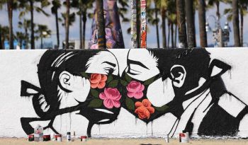 Graffiti image of two people kissing through face masks