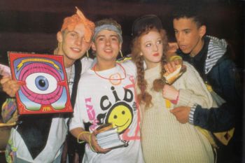 Three men and one woman dressed in 80s acid house clothing