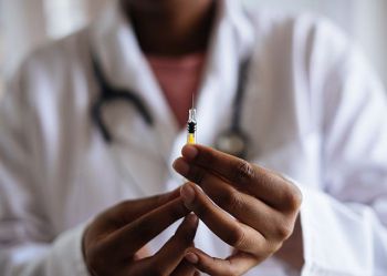 A doctor holding an injection in her hands