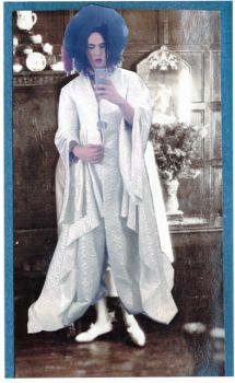 Photo collage of a gender-ambiguous figure posing in a broad timmed hat and long white robes holding a smartphone toward the viewer as if taking a selfie. The background is a sepia toned early to mid 1900s photograph showing a wood-panneled interior,