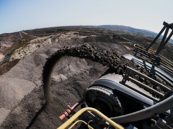 Coal goes flying off the end of a conveyor belt on a coal mining site