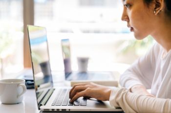 A woman reading from a laptop