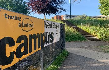 An image of Better Campus signage on a construction work fence on the Arts Path