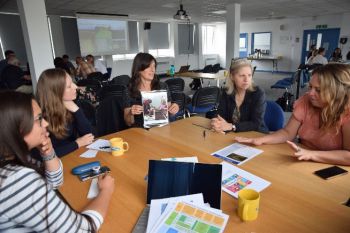 Group of people sitting around a table discussing and sharing their perspectives during an interactive workshop