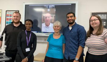 Dr Graham Davis (on screen) with Lady Margaret Kroto standing between four Kroto JRA students