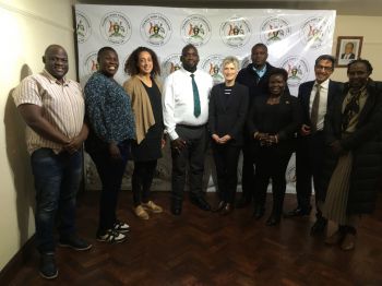 Ugandan MPs together with the project team are smiling into the camera and posing for a picture