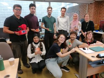 Group of students seated and standing posing with their 3D models