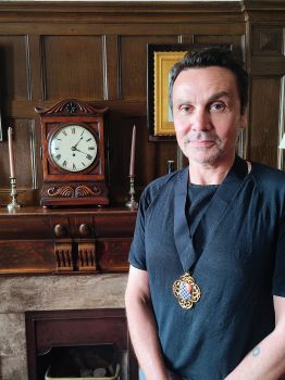 Cllr Matthew Bird - a white man with dark hair standing by the mantelpiece in the Mayor's office