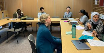 ELAS tutor and students discussing around a table