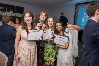 Photo of four students from MAH smiling as they hold up their awards
