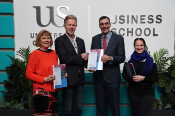 Merrill Jones, Dr René Moolenaar, Prof Steven McGuire, Caroline Barrow holding a printed copy of the Carbon Literacy training report