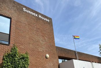 Pride progress flag flying over Sussex House