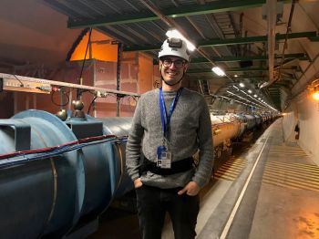 A man wearing a workman hat standing in a tunnel