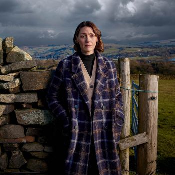 Suranne Jones standing in front of a rocky landscape