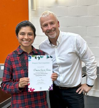 Grecia Garcia Garcia is presented with a certificate for winning the ECR Dragons' Den competition. She poses with Peter Lane, both smiling at the camera.