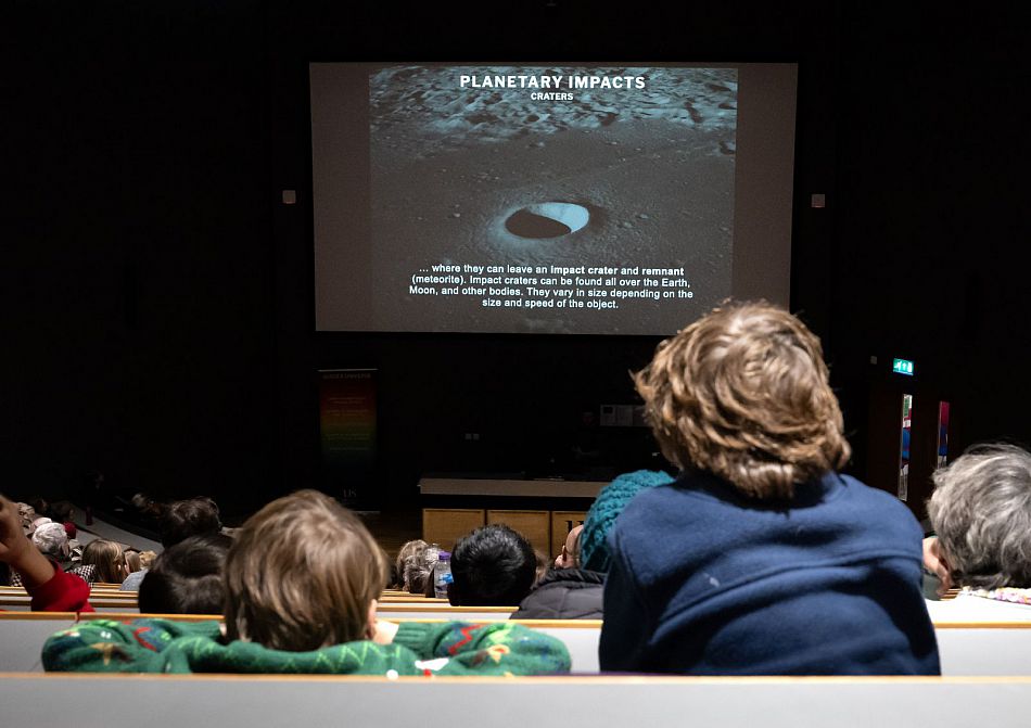 young audience watching a talk in a lecture theatre