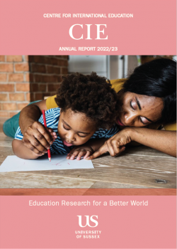 image of CIE's annual report front cover - features a woman teaching a toddler how to write 