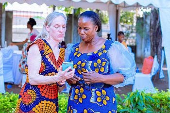 Sarah Stephens showing her digital legal assistant on a mobile to another woman. Sarah Stephens showing her digital legal assistant on a mobile to another woman.